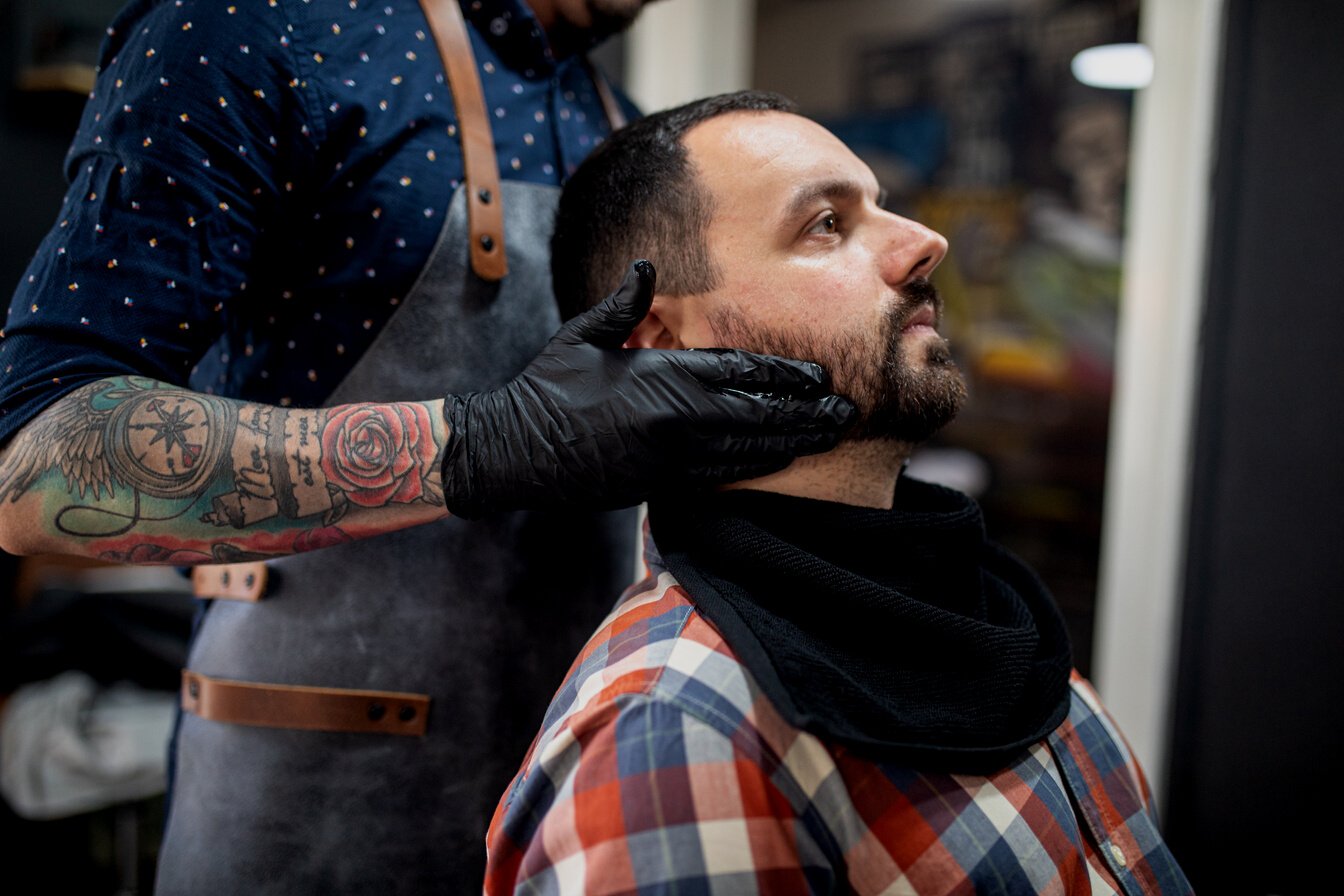 Barber adjusting his customer's head