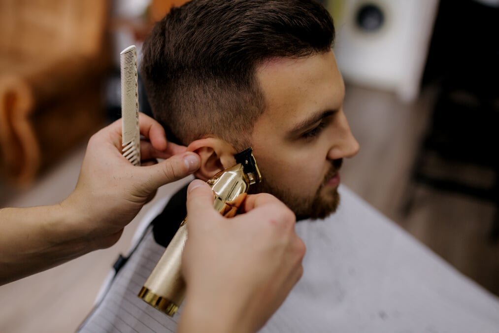 Hairdresser using Hair Clipper for Fringing Hair of Bearded Man